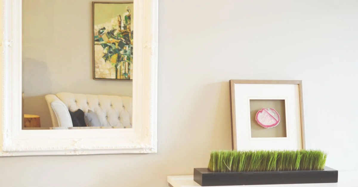 Un salon magnifiquement décoré avec un grand miroir, une peinture abstraite et un décor minimaliste.