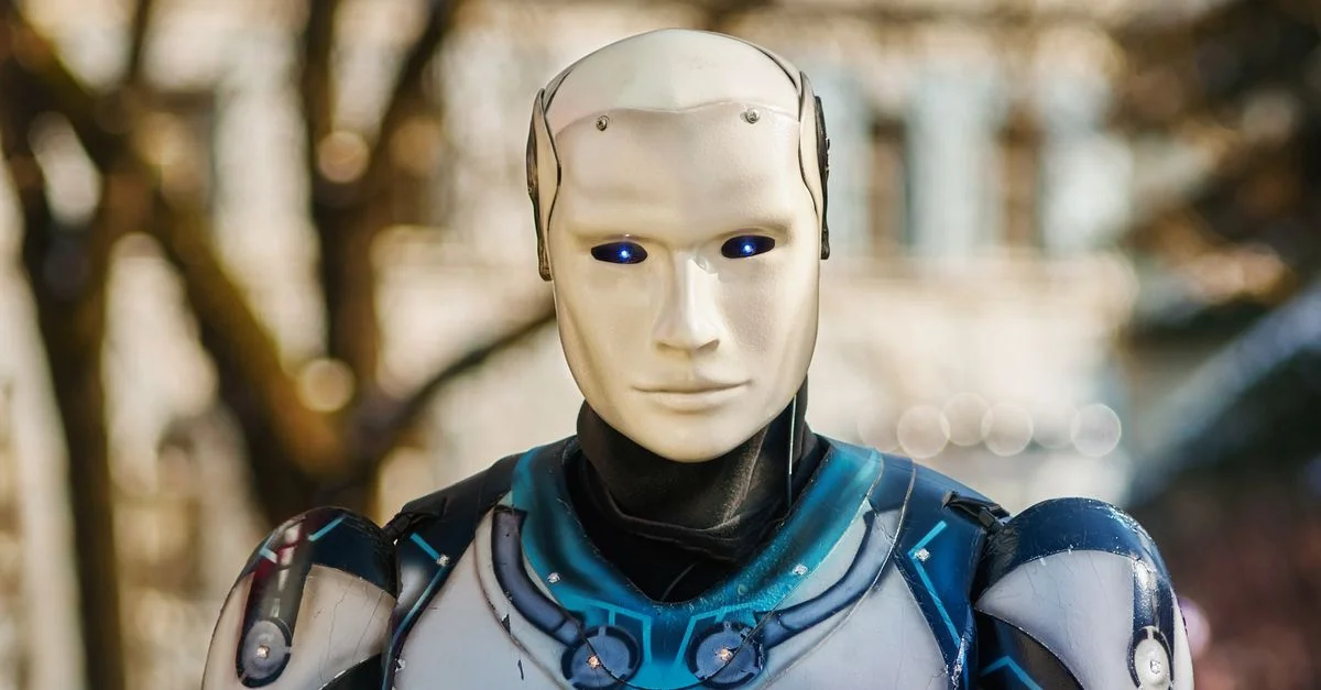 Gros plan sur un robot humanoïde au design futuriste posant en extérieur.